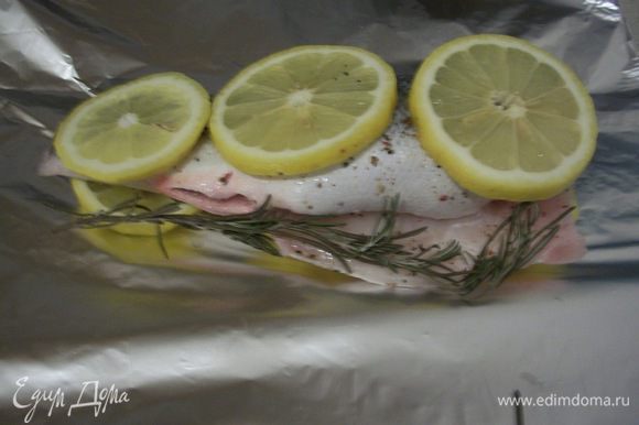 Рыбу выложить на лимон, чтобы не пригорела. Положить рядом веточку розмарина. Завернуть в фольгу и запекать 20 - 25 минут при температуре 180 - 200 градусов.