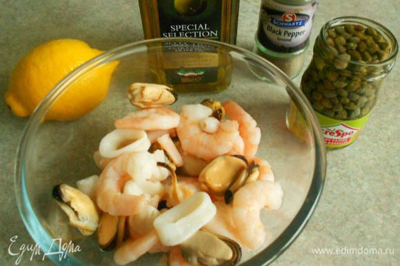 Морепродукты разморозить, смешать с перцами, каперсами и петрушкой. Взбить вилкой в миске все компоненты заправки и полить салат.