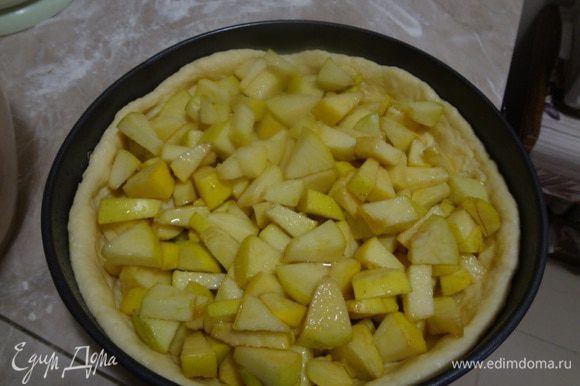 Настоявшиеся яблоки в сахаре выложить аккуратно на тесто ложкой. На дне посуды, в которой были яблоки будет сок, его либо выливать не весь, если много, либо полить сверху выложенные яблоки. Надо следить, чтобы этот сок не вылился сразу на тесто, иначе тесто может размокнуть, лучше попридержать сок, и полить им яблоки сверху.