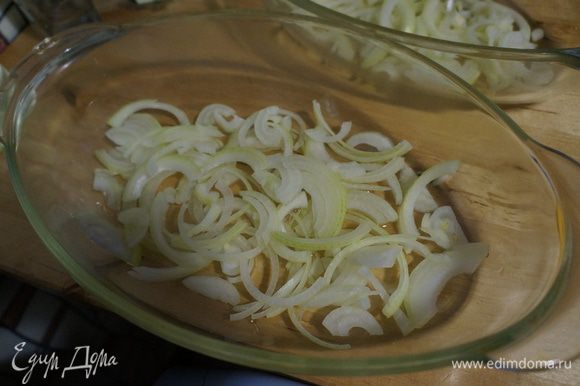 Луковицы нарезать полукольцами, форму для выпечки смазать растительным маслом, на которое выложить луковую подушку