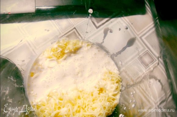 Добавляем тертый на мелкую терку сыр и заливаем сливки. Всё взбиваем миксером на маленькой скорости. Заливаем наш пирог готовой заливкой и ставим в разогретую до 180 гр. духовку на 40 -45 минут