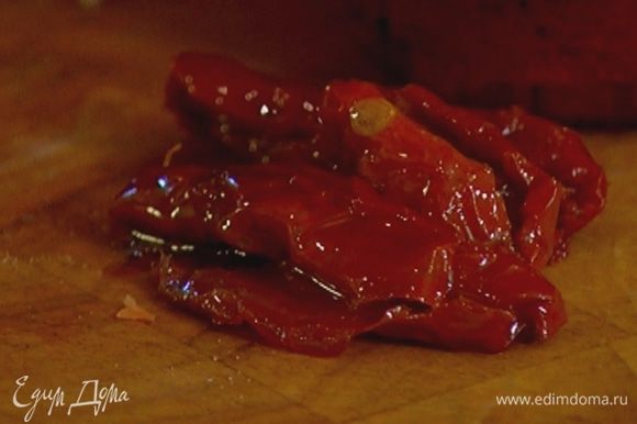 Вяленые помидоры порезать небольшими кусочками и выложить к бекону.