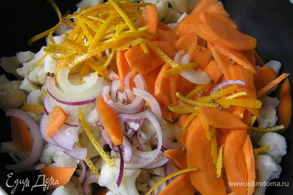 В сотейник с толстым дном выложить капусту, морковь, лук и цедру. Залить половиной соуса и варить 10-12 минут до готовности.