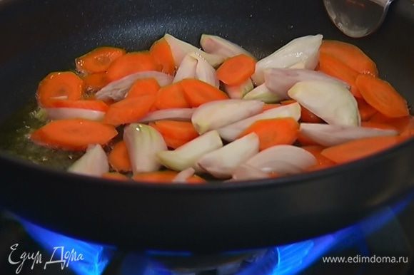 Разогреть в тяжелой сковороде со съемной ручкой 1 ст. ложку оливкового масла и обжарить лук и морковь до золотистого цвета.