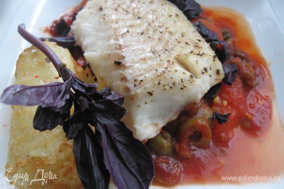 На базилик положить рыбу. Вокруг томатной подушки — соус с оливками. Сбоку для украшения положить сырные «чипсы» и веточку базилика.