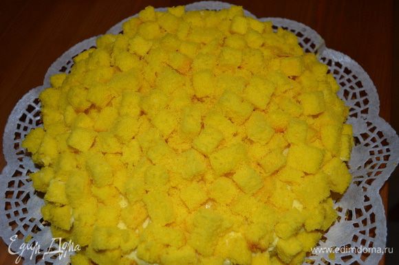 А затем покрываем всю поверхность торта нарезанными ранее кубиками бисквита! Крем позволяет кусочкам бисквита как следует закрепиться на поверхности торта, и он начинает походить на мимозу - такой же нежный, воздушный и...........желтый! )))