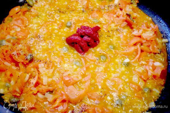В сковороде, где обжаривалась рыба, пассеруем мелко порезанную морковь, лук-порей, порубленный чеснок, добавляем томатную пасту, мякоть помидоров и каперсы. Добавляем овощи в суп.
