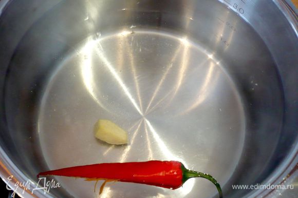 В кастрюле доводим до кипения воду, бросаем в нее очищенный от семян перец-чили и почищенный имбирь, а затем спагетти. Варим до готовности около 10 минут.