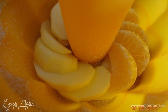 Форму смазать маслом и посыпать манкой, выкладывать поочередно фрукты и тесто, пока не заполнится форма.