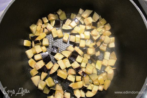 В кастрюле с плотным дном разогреть 80 мл оливкового масла, обжарить в нем порциями на сильном огне баклажаны, добавляя оливковое масло если необходимо.