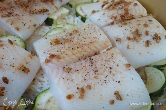Посыпать смесью специй рыбу. Разложить рыбу в один слой на рис, приправленной стороной вверх, накрыть крышкой и варить, пока рис не станет мягким и рыбы непрозрачна, от 7 до 10 минут.