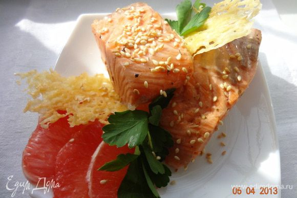 Готовую рыбу выложить на тарелку, чтобы чуть полежала, подавать теплой, украсив зеленью, кунжутом и сырными чипсами.