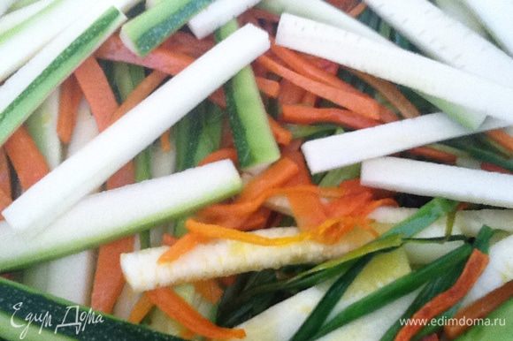 Добавляем лук - порей, можно морковь немного отодвинуть в сторону, и слегка прогреваем его 1 минуту до мягкости. Перемешиваем с морковью. И на эту подушку выкладываем брусочки цуккини. Посыпаем сухим майораном, перемешиваем очень аккуратно.