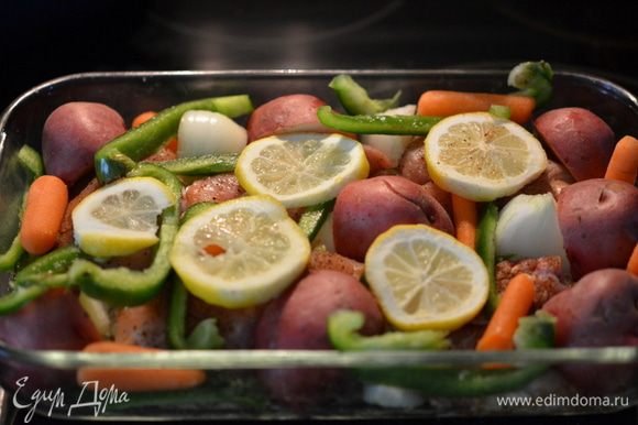 Поверх выложить овощи. Сверху лимон колечками. Прикрыть фольгой. Поставить в духовку на 45 - 55 мин.