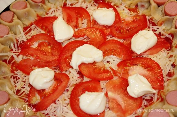 Помидор нарезать на тонкие пластинки и разложить их на поверхности пиццы. Поверх него выложить мягкий сливочный сыр небольшими порциями