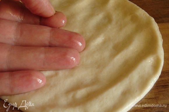 Положить кусок смоченного в масле теста на рабочий стол и размять его пальцами. Затем ладонью и пальцами, слегка нажимая на тесто, разгладить (!) тесто по столу до очень тонкого блинчика. Это очень несложная процедура! Если поверхность блинчика окажется недостаточно масляной, можно смочить пальцы в масле и размазать его по блину.