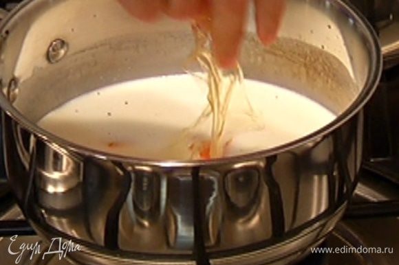 Как только в молоке со сливками появятся первые пузырьки, добавить желатин, снять кастрюлю с огня, удалить апельсиновую цедру и стручок ванили, все перемешать.