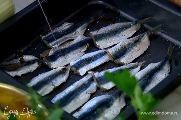 В небольшой глубокий противень влить 1 ст. ложку оливкового масла, посолить, поперчить и выложить рыбу спинкой вверх.