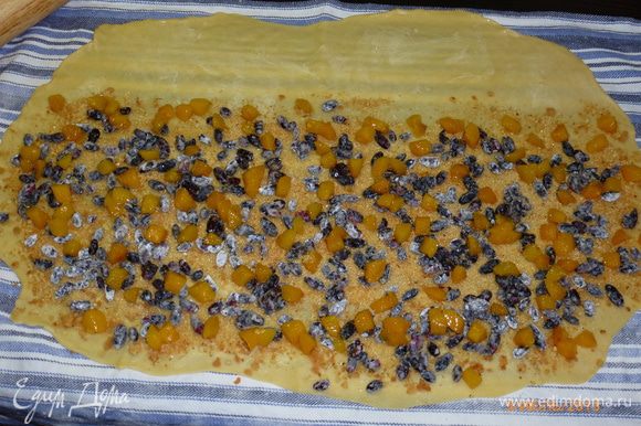 Поверх печенья выкладываем жимолость и абрикосы. Посыпаем сахаром. Оставшееся сливочное масло нарезаем кубиками и выкладываем на начинку.