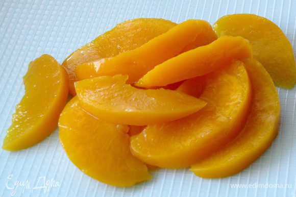 С консервированных персиков слить жидкость, персики нарезать на небольшие тонкие дольки.