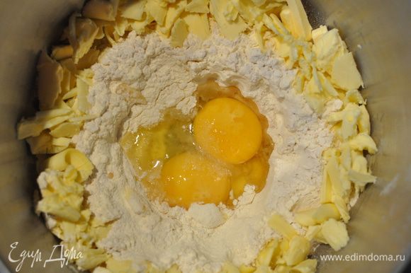 Займёмся тестом. Здесь всё просто, особенно для любителей тартов. В чашу блендера просеять муку и сахарную пудру. В середину поместить яйцо, желток и соль, по краям - нарезанное кусочками масло. С помощью насадки для теста эта масса быстро превратится в шар.