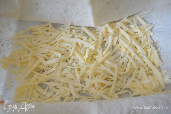 На дно формы с лавашом раскладываем 1/3 часть сыра.