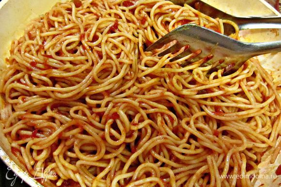 Спагетти смешайте с томатным соусом, добавьте половину натёртого сыра и прогрейте на огне 1 мин.