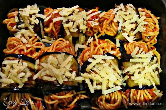 На середину каждого ломтика баклажана выложите немного спагетти и скатайте рулетики. Выложите рулетики на смазанный оливковым маслом противень и сверху посыпьте оставшимся сыром. Запекайте 10 мин при 200г.