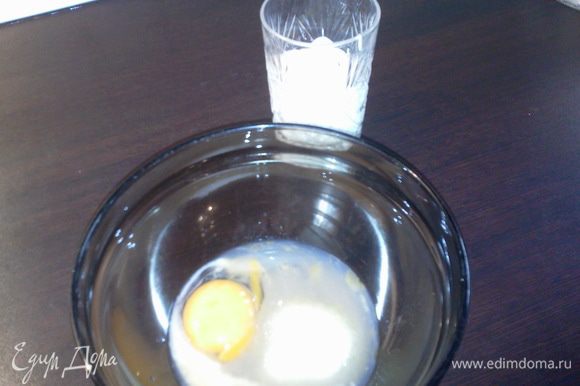 В отдельной миске взбить яйцо с сахаром, сметаной и погашенной содой