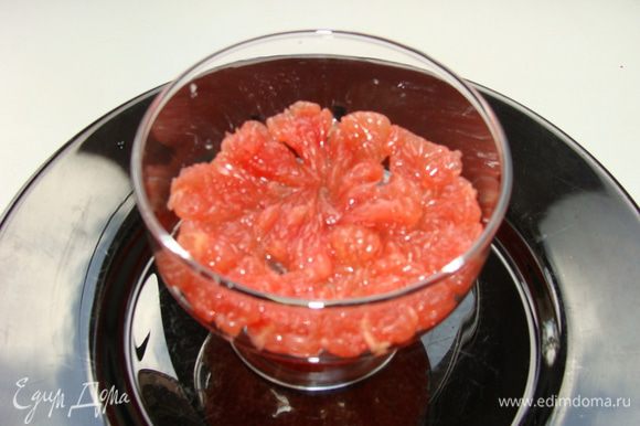 Грейпфрут очистить от пленочек, мелко порезать и выложить нижним слоем в порционные креманки.
