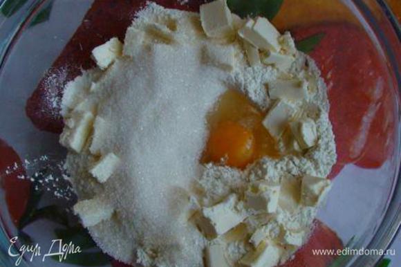 Всыпать в миску муку, добавить разрыхлитель, яйцо, соль и сахар, порезанное на кусочки масло.