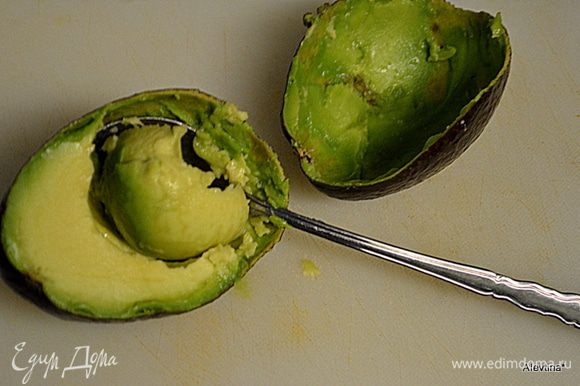 Разрезать авокадо на две части ножом. Очистить от кожуры.