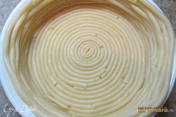 Круглую форму смазать сливочным маслом. Начиная с центра, выложить по кругу дно и бока формы макаронами.
