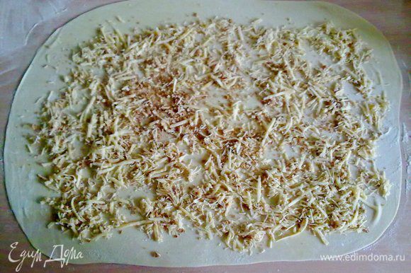 Тесто раскатать в тонкий пласт и распределить сыр с сухарями.