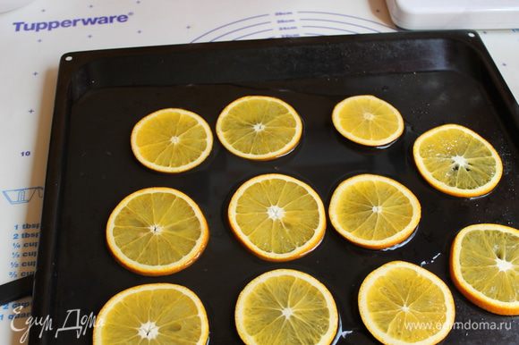 Пока бисквит печется , апельсины нарезаем шириной примерно 0,4мм, кладем кружки на лист посыпаем сахаром (80гр) и поливаем водой смешаной с лимонным соком.