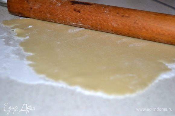 Стол припорошить сахарной пудрой и раскатать марципан по размеру формы. Ничего страшного если марципановая масса не будет идеально ровная.