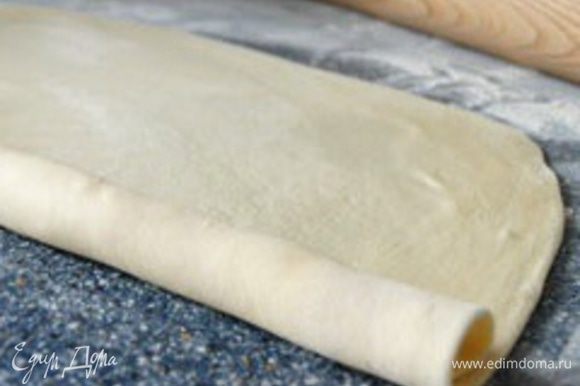 Раскатайте тесто в очень тонкий пласт и смажьте растопленным жиром по всей поверхности.