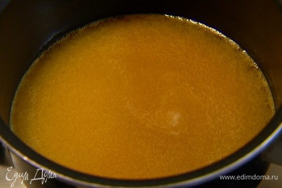 Приготовить карамель: апельсиновый сок влить в небольшую кастрюлю, добавить сахар, поместить на огонь и сварить карамель.