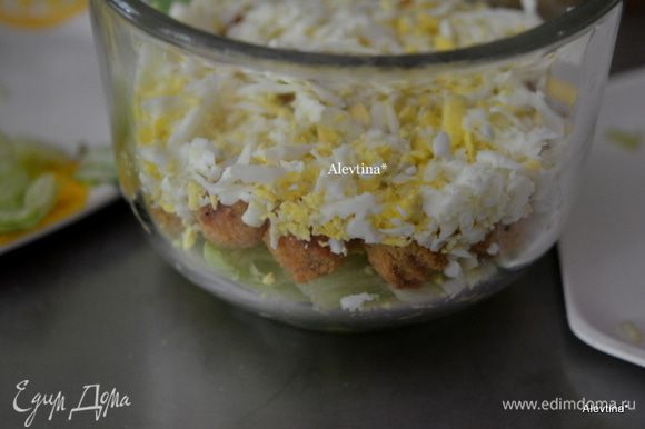 Выложить слоями сначала салатные листья, затем готовое и мелко порезанное куриное мясо, яйца сваренные вкрутую на крупной терке.