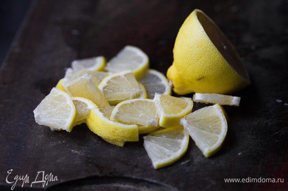 Лимон помойте, половину нарежьте на четвертинки.
