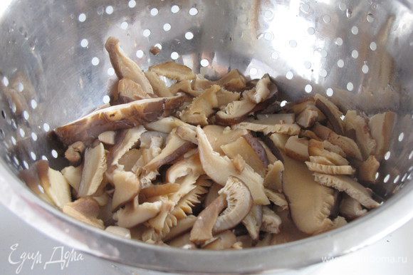Через 20 минут слить жидкость и слегка отварить грибы, минут 5-7. Откинуть на дуршлаг, остудить. Если использовать свежие грибы шиитаке или шампиньоны, то эти операции можно опустить.