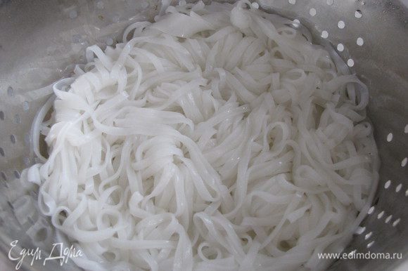 Рисовую лапшу отварить, как написано на упаковке. Отбросить на дуршлаг, промыть холодной водой.
