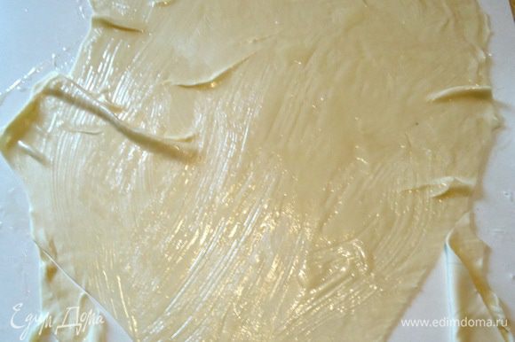 Первый пласт срезать на угол и скрутить немного растягивая тесто на себя. Смазанное тесто очень податливое. Край пласта оставить не свернутым примерно 10 см.