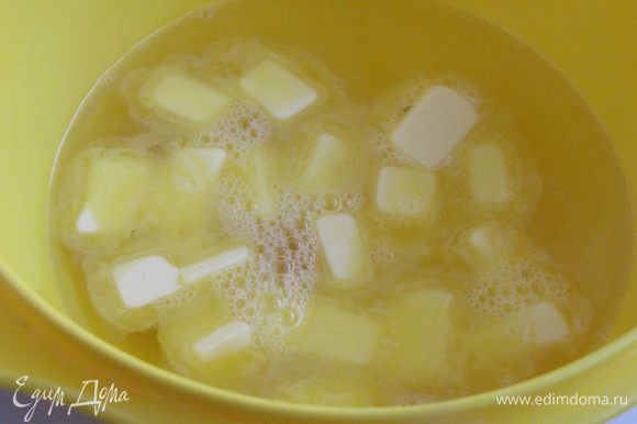 Пока варится бульон, приготовим галушки. Масло, заранее вынутое из холодильника, порезать на кусочки. Добавить 0,5 стакана крутого кипятка и соль. Перемешать.