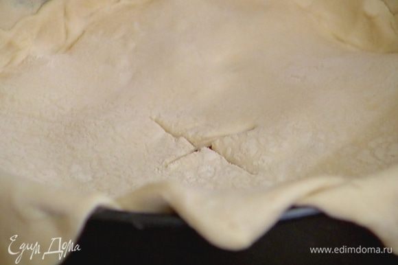 Защипнуть тесто по краю формы над начинкой, чтобы не вытекал сок, посередине верхнего пласта теста сделать крестообразный надрез.