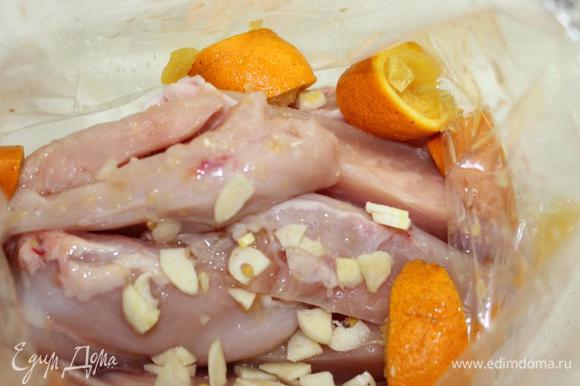 Куриную грудку освободить от кожи и грудной кости, нарезать на продольные кусочки, уложить в пакет для запекания. Добавить нарезанный чеснок, сок двух апельсинов и нарезанную на дольки кожуру апельсинов.