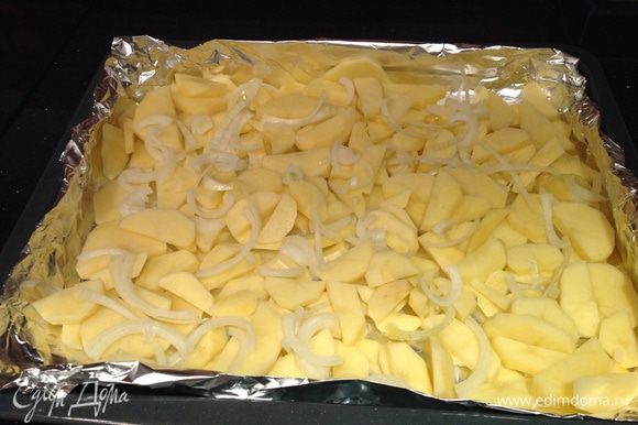 Картофель и лук почистить и порезать кусочками. Выложить на застеленный фольгой противень, посолить, сбрызнуть оливковым маслом.