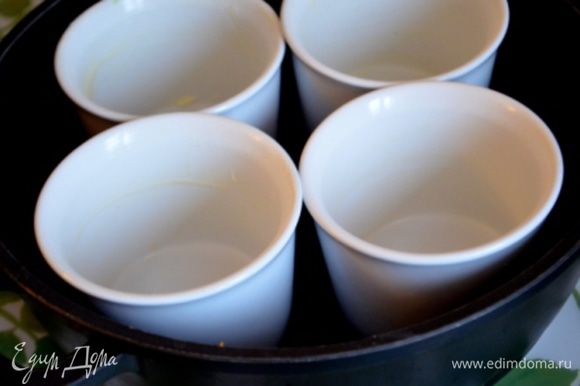 Формочки для суфле (или 1 большую) смазать оставшимся сливочным маслом, поставить их в бОльшую форму и влить горячую воду до половины маленьких формочек).