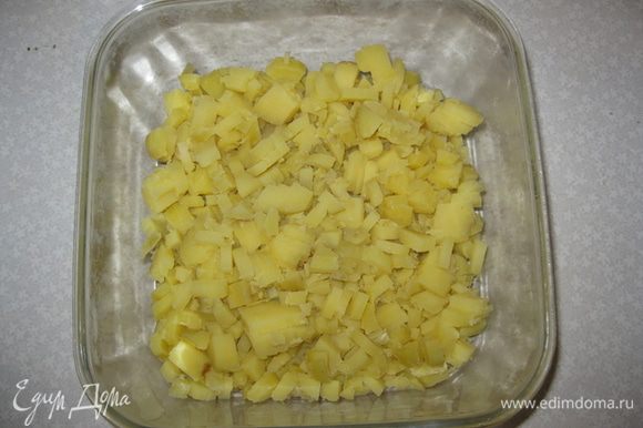 На дно выкладываем тонким слоем оливковый майонез "Слобода". Чистим отварной картофель в мундире. Режим его квадритиками и выкладываем 1-й слой.