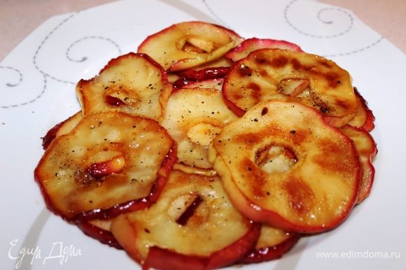 Пока гусь запекается приготовить для подачи карамелизованные яблоки: вынуть из них сердцевину, нарезать кругляшками, поджарить на сковороде в сливочном масле и сахаре, присыпать перцем